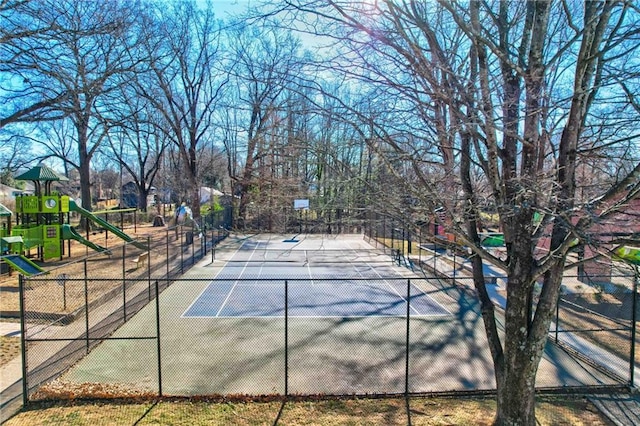 view of tennis court featuring a playground