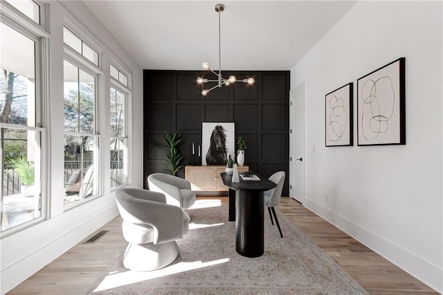 dining space featuring light hardwood / wood-style flooring and an inviting chandelier