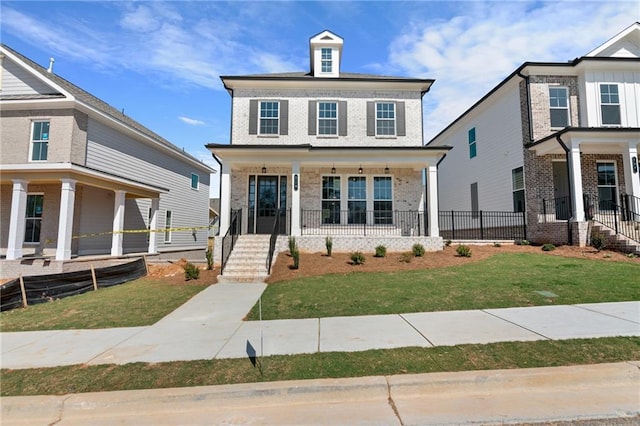 traditional style home featuring a porch, brick siding, and a front yard