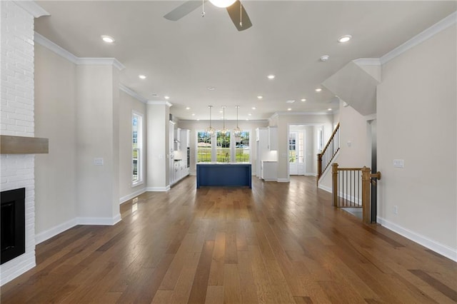 unfurnished living room with baseboards, dark wood-style flooring, a fireplace, and crown molding