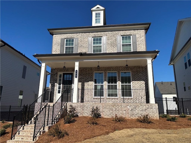 view of front facade featuring stairway, brick siding, a porch, and fence