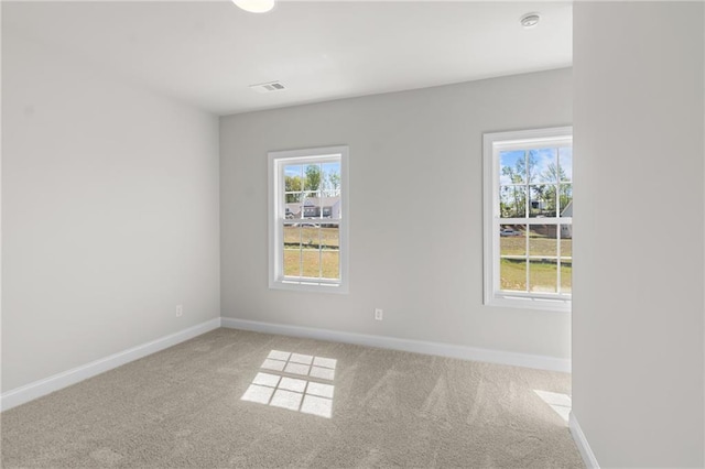 spare room with baseboards, carpet floors, and visible vents