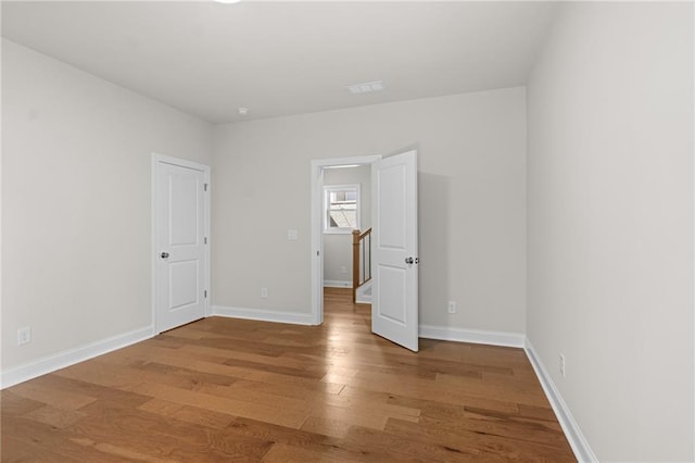 empty room featuring baseboards and wood finished floors