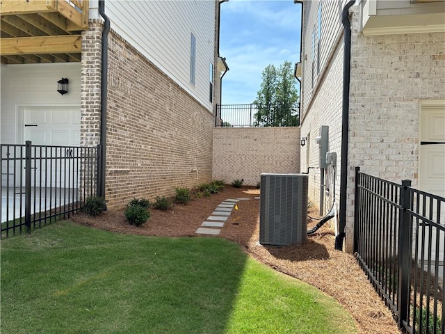 view of yard with central air condition unit and fence