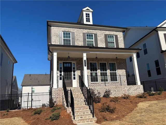 view of front of house with brick siding, a porch, and fence