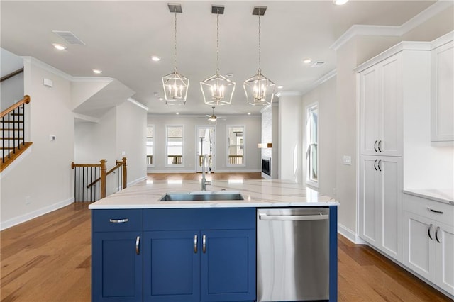 kitchen with blue cabinets, a sink, open floor plan, white cabinets, and dishwasher