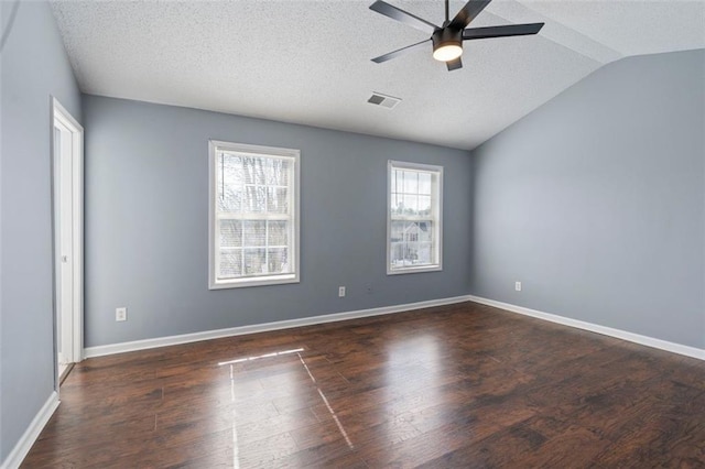 spare room featuring dark hardwood / wood-style flooring, a textured ceiling, vaulted ceiling, and ceiling fan