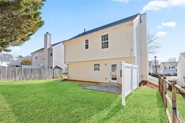 back of house with a yard and a patio