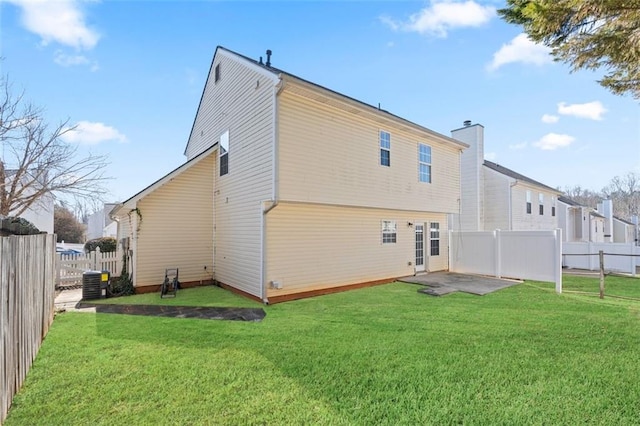 rear view of house with cooling unit, a yard, and a patio area