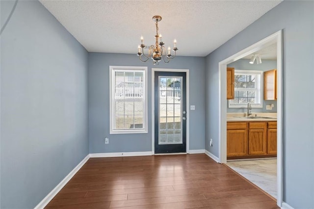 entryway with sink, hardwood / wood-style floors, a textured ceiling, and a chandelier