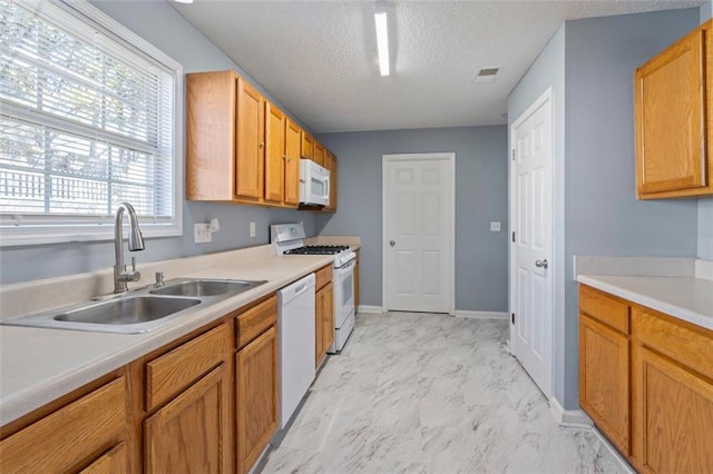 kitchen with white appliances, sink, and a textured ceiling