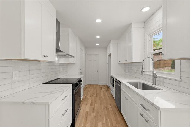 kitchen with wall chimney range hood, a sink, black electric range, recessed lighting, and stainless steel dishwasher