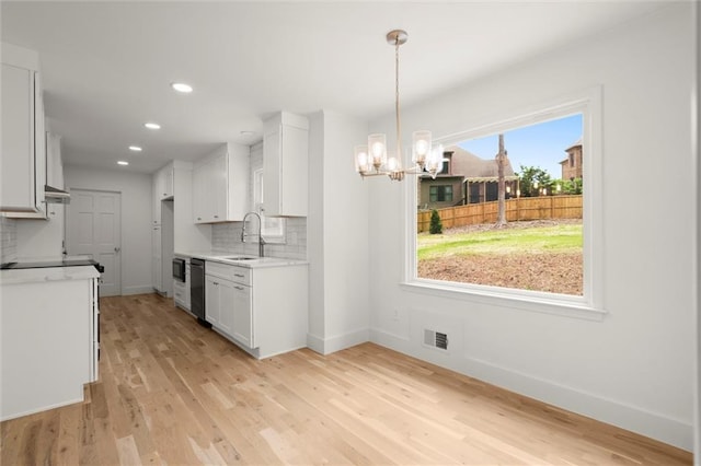 kitchen featuring visible vents, decorative backsplash, an inviting chandelier, a sink, and dishwasher
