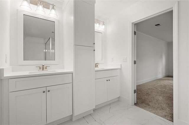 bathroom featuring a sink, baseboards, two vanities, and marble finish floor