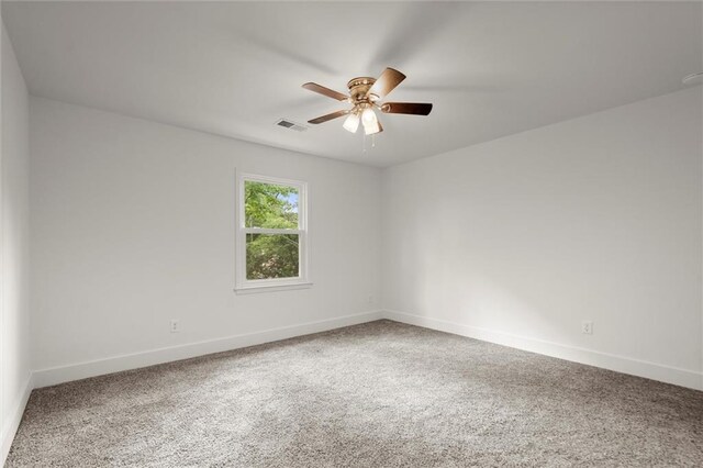 carpeted spare room with a ceiling fan, baseboards, and visible vents