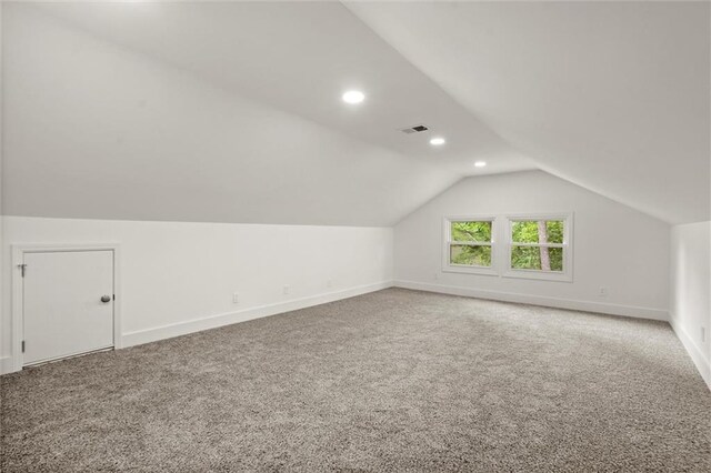 bonus room with carpet floors, baseboards, visible vents, and lofted ceiling