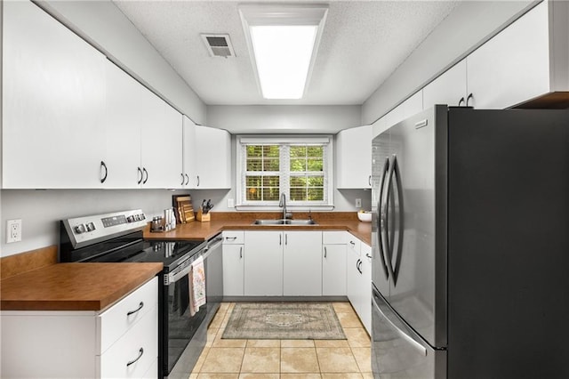 2349 Northlake Ct NE, Atlanta, GA 30345 - kitchen featuring appliances with stainless steel finishes, a sink, white cabinetry, dark countertops, and light tile patterned flooring