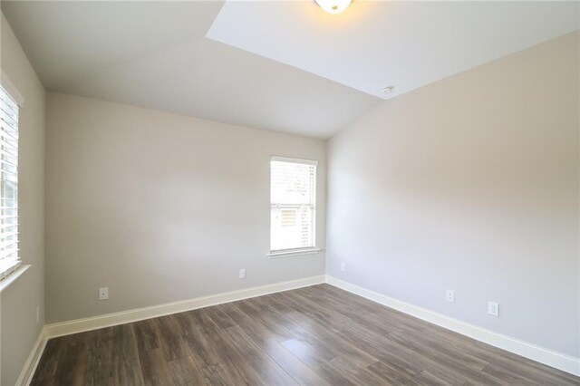 unfurnished room featuring lofted ceiling and dark wood-type flooring