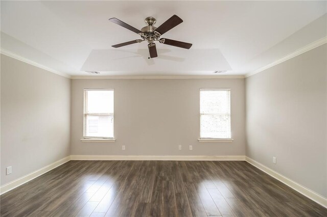 empty room with ceiling fan, a tray ceiling, ornamental molding, and dark hardwood / wood-style floors