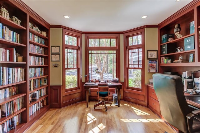 office featuring recessed lighting, bookshelves, ornamental molding, and wood finished floors