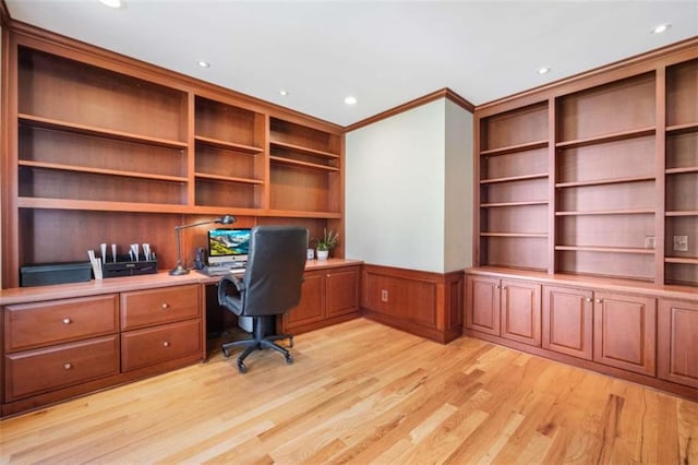 unfurnished office featuring crown molding, built in features, recessed lighting, wainscoting, and light wood-style floors