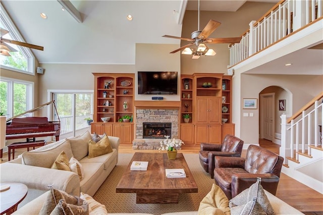 living room with light wood-style flooring, high vaulted ceiling, and a ceiling fan