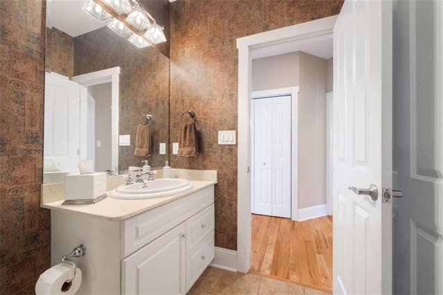 bathroom with baseboards, vanity, and tile patterned flooring