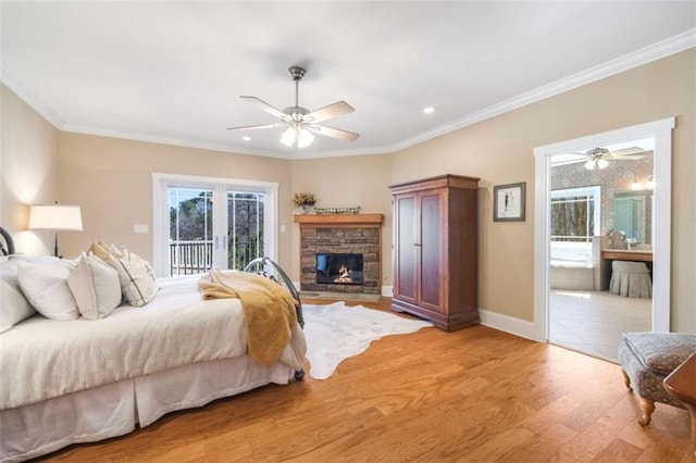 bedroom featuring a stone fireplace, light wood-style flooring, crown molding, and access to outside