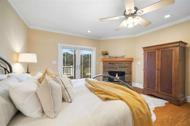 bedroom featuring access to outside, a stone fireplace, crown molding, light wood finished floors, and baseboards