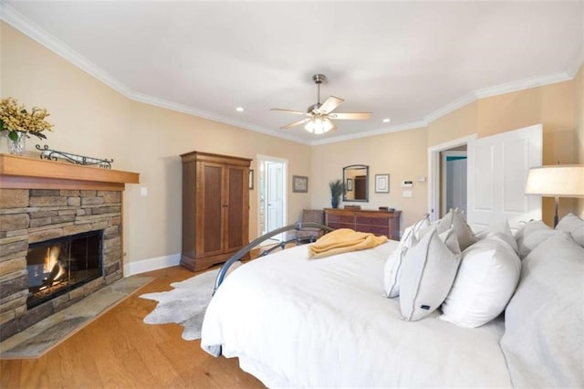 bedroom featuring light wood-style flooring, a fireplace, and crown molding