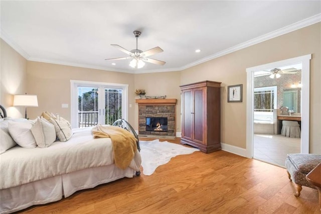 bedroom with access to outside, crown molding, light wood-style floors, a fireplace, and baseboards