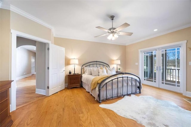 bedroom with arched walkways, light wood-style flooring, access to exterior, and ornamental molding