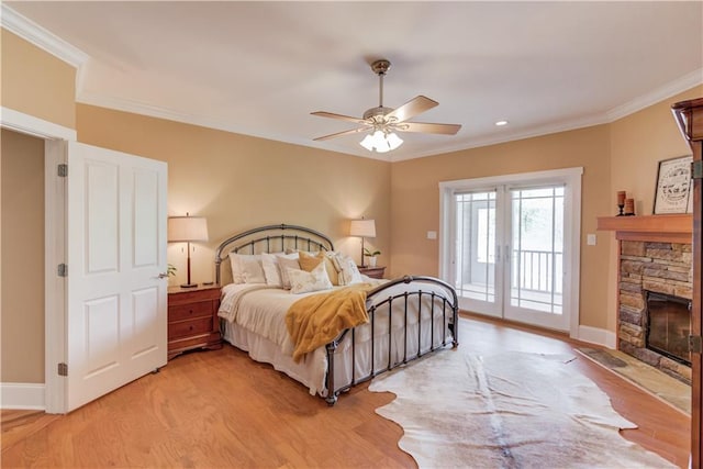 1126 Shoreline Dr, Jefferson, GA 30549 - bedroom featuring access to outside, light wood-type flooring, crown molding, a stone fireplace, and baseboards