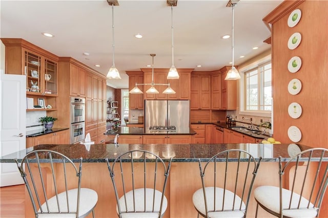 kitchen featuring a sink, a healthy amount of sunlight, a large island, and stainless steel appliances