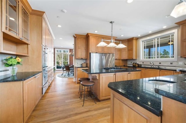 kitchen with light wood-type flooring, a kitchen island, backsplash, recessed lighting, and stainless steel appliances