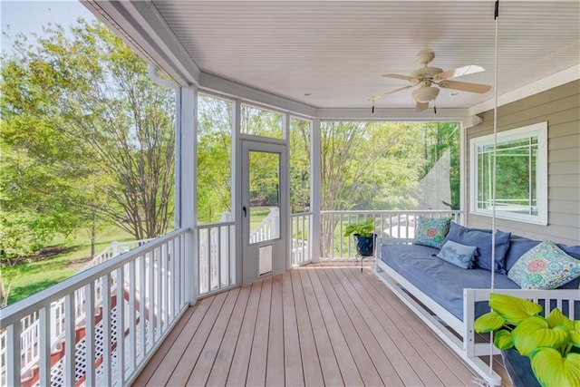 unfurnished sunroom with an outdoor living space and a ceiling fan