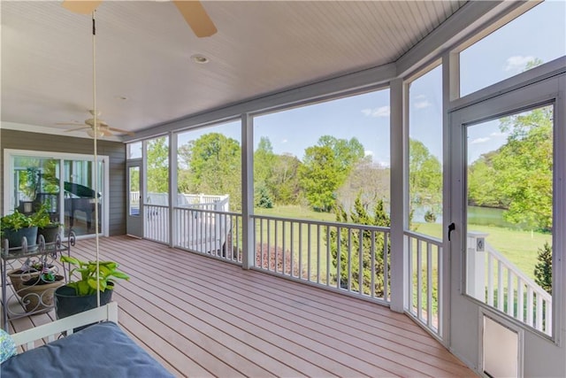 unfurnished sunroom featuring a ceiling fan
