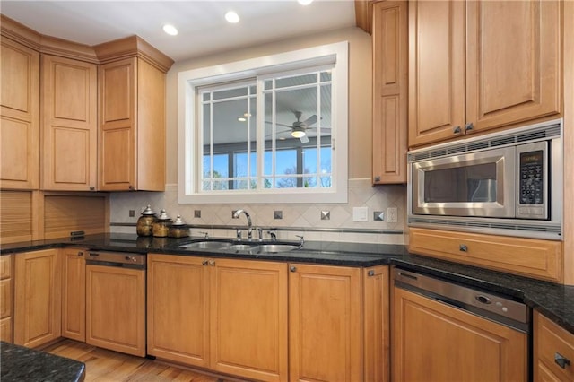1126 Shoreline Dr, Jefferson, GA 30549 - kitchen with stainless steel microwave, a sink, a ceiling fan, dark stone counters, and backsplash