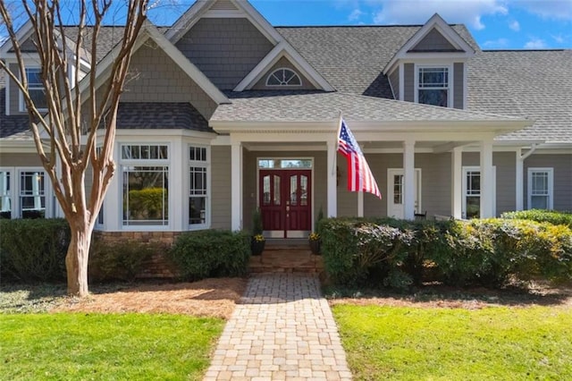 view of front facade featuring french doors and roof with shingles