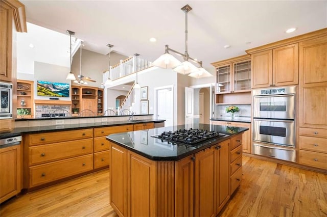 kitchen featuring open shelves, a warming drawer, a center island, and stainless steel appliances