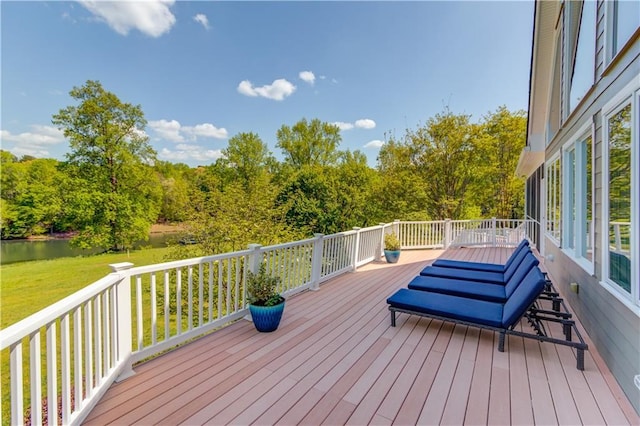 wooden terrace with a yard and a water view