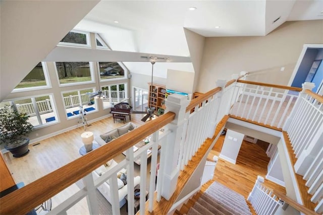 staircase with visible vents, baseboards, recessed lighting, wood finished floors, and high vaulted ceiling