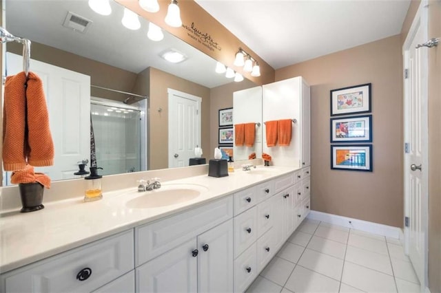 bathroom with visible vents, baseboards, a sink, double vanity, and a stall shower