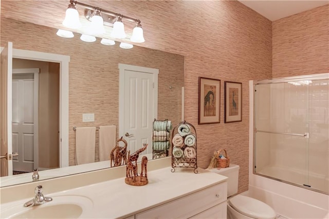 full bathroom with toilet, wallpapered walls, vanity, and combined bath / shower with glass door