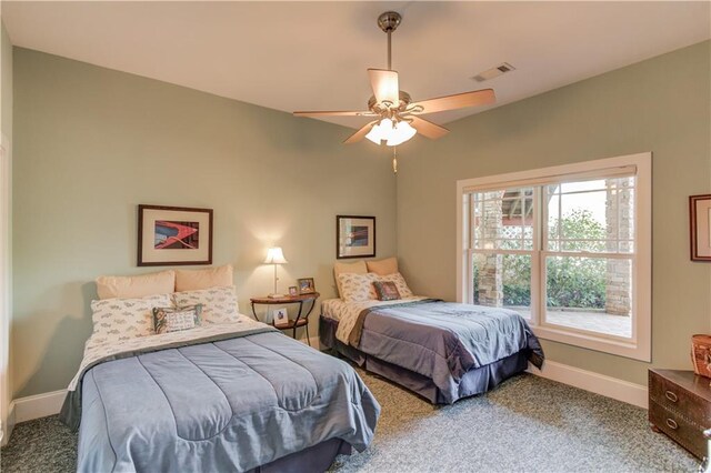 carpeted bedroom with visible vents, baseboards, and ceiling fan