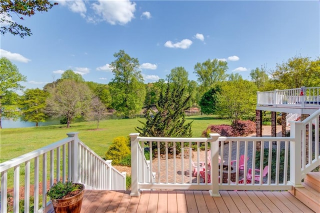 wooden terrace featuring a water view and a lawn