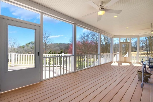 unfurnished sunroom with ceiling fan