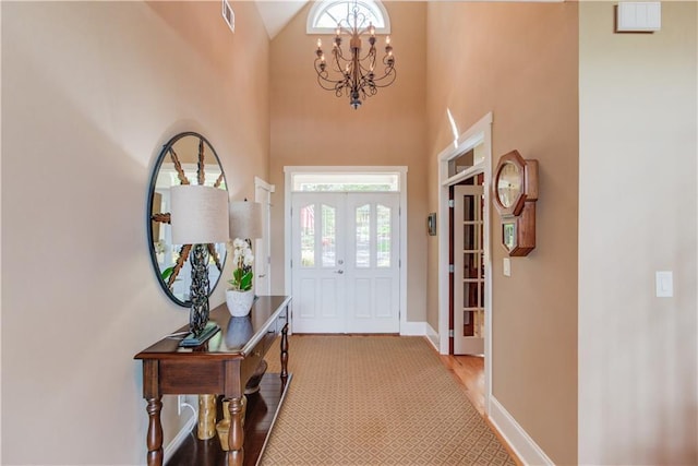 entryway with visible vents, baseboards, an inviting chandelier, and wood finished floors
