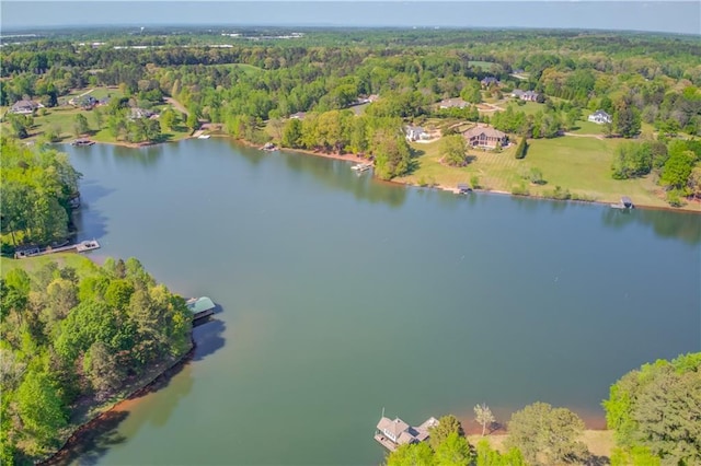 drone / aerial view with a wooded view and a water view
