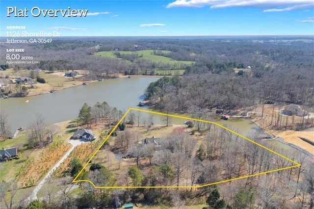 aerial view featuring a wooded view and a water view